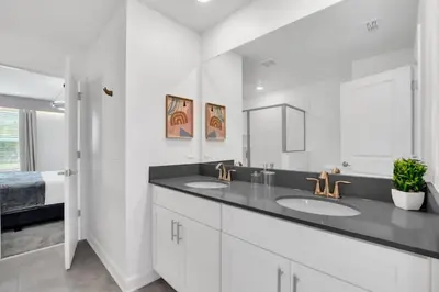 a white bathroom with two sinks and a mirror at Perfect Disney Vacation Home in Kissimmee