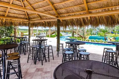 a patio with tables and chairs and a swimming pool at Perfect Disney Vacation Home in Kissimmee