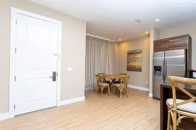 a kitchen and dining room with a table and a refrigerator at Modern and Luxury 4 suites close to Disney 7544 in Orlando
