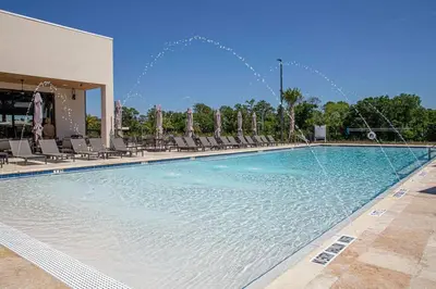 a large swimming pool with chairs and water fountains at Modern and Luxury 4 suites close to Disney 7544 in Orlando