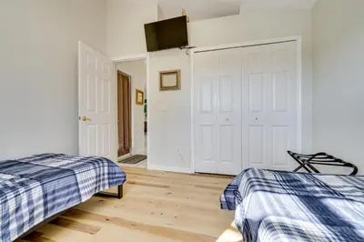 a bedroom with two beds and a tv on the wall at 4 Mi to Disney Family Getaway with Game Room! in Kissimmee