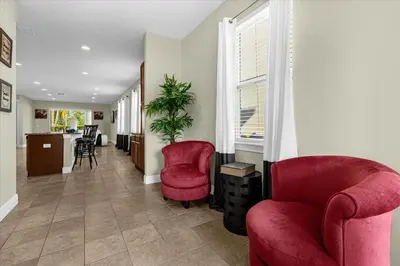 a living room with two red chairs and a window at Multiple Family Homes 16 Rooms - PoolSpa in Orlando