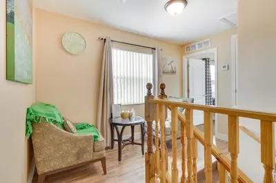a living room with a staircase and a chair at 25 Mi to Disney Home with Shared Pool in Orlando in Orlando