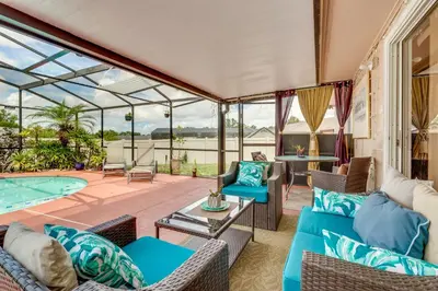 a conservatory with a couch and chairs and a pool at 25 Mi to Disney Home with Shared Pool in Orlando in Orlando