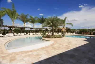 a pool at a resort with palm trees at 43 Townhouse Near Disney!! in Kissimmee
