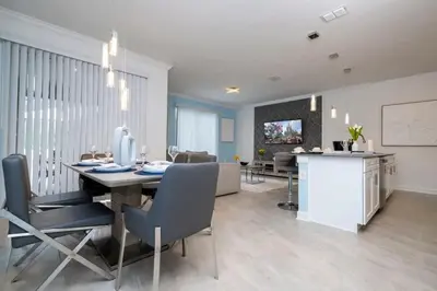 a dining room and living room with a table and chairs at Marvelous 4Bd with Pool at Storey Lake Resort 2601 in Kissimmee