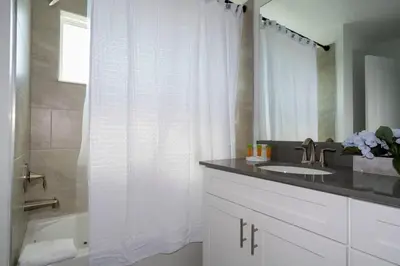 a bathroom with a white shower curtain and a sink at Marvelous 4Bd with Pool at Storey Lake Resort 2601 in Kissimmee