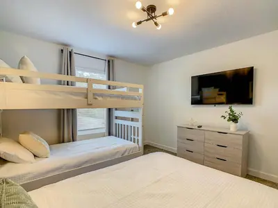 a bedroom with a bunk bed and a tv at 4BR Townhouse with Private Pool near Disney in Kissimmee