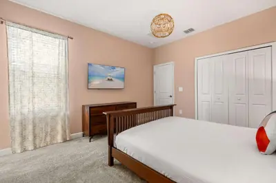 a bedroom with a bed and a large window at Upstay Modern 5BR Resort Home w Pool & Hot Tub in Kissimmee