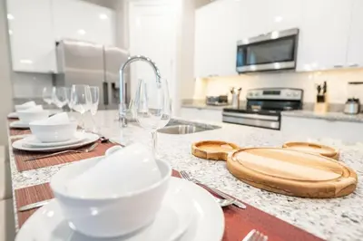 a kitchen counter with wine glasses and a cutting board at 7988 Magical 5BD Home Perfect Disney Retreat in Kissimmee