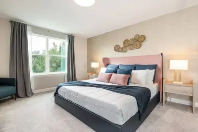 a bedroom with a large bed with blue and pink pillows at 7988 Magical 5BD Home Perfect Disney Retreat in Kissimmee