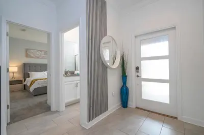 a white bedroom with a mirror and a bed at 2941 Modern Four Bedroom Locate at Storey Lake in Kissimmee