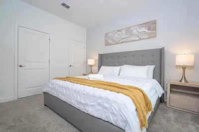 a bedroom with a large bed with a gold blanket at 2941 Modern Four Bedroom Locate at Storey Lake in Kissimmee