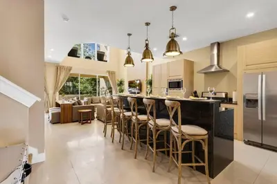 a kitchen and living room with a bar with stools at Luxury Townhouse located NEXT to DISNEY ORLANDO in Orlando