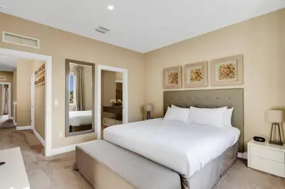 a bedroom with a large white bed and a mirror at Luxury Townhouse located NEXT to DISNEY ORLANDO in Orlando