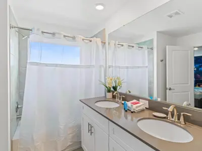 a bathroom with two sinks and a large mirror at Gorgeous Condo Close to Disney w Private Pool BBQ - Themed Bedrooms Walk To Clubhouse in Kissimmee