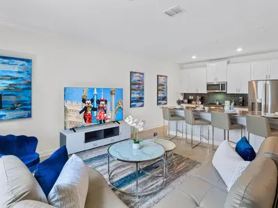 a living room with a couch and a table at Gorgeous Condo Close to Disney w Private Pool BBQ - Themed Bedrooms Walk To Clubhouse in Kissimmee