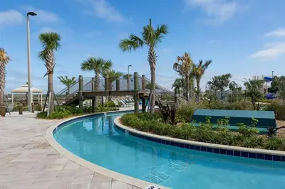 a swimming pool with a wooden bridge and palm trees at Gorgeous Condo Close to Disney w Private Pool BBQ - Themed Bedrooms Walk To Clubhouse in Kissimmee