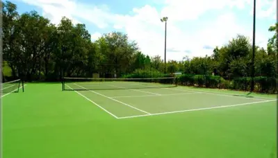a tennis court with a green tennis court at bsv_villa8445 in Kissimmee