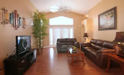 a living room with a leather couch and a television at Emma Castle - private fenced home 3 miles to Disney in Kissimmee