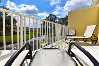 a patio with a table and chairs on a balcony at Beautiful 3-Bed Villa 10 Minutes From Disney - Serenity Resort townhouse in Orlando