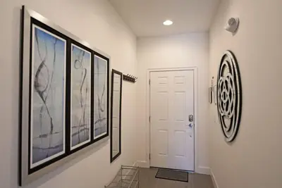 a hallway with three pictures on the walls and a white door at Beautiful 3-Bed Villa 10 Minutes From Disney - Serenity Resort townhouse in Orlando