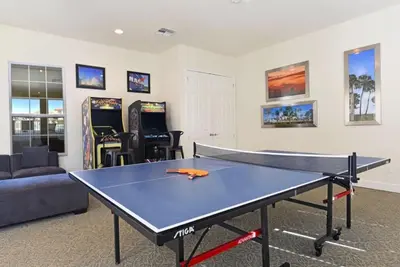 a ping pong table in a living room with a ping pong ball at 3 Bedroom Private Pool With Spa Near Disey villa in Orlando