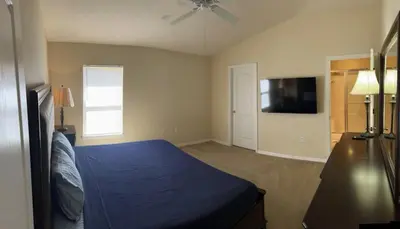 a bedroom with a blue bed and a flat screen tv at 3 Bedroom Private Pool With Spa Near Disey villa in Orlando
