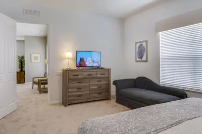 a bedroom with a couch and a tv on a dresser at Penthouse Utopia condo in Orlando
