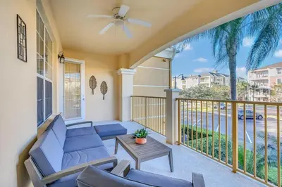 a porch with a couch and chairs and a table at Vista Cay Magic condo in Orlando