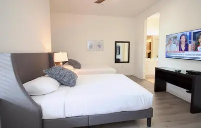 a bedroom with a white bed and a television at NEW! Vista Cay Luxury Mirage condo in Orlando