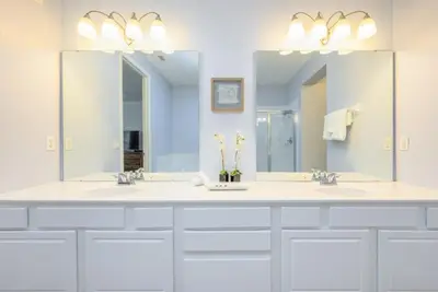 a bathroom with two sinks and two mirrors at Vista Cay Electra condo in Orlando