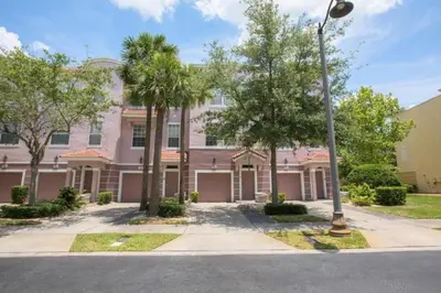 a pink building with palm trees and a street light at Vista Cay Casa Bonita townhouse in Orlando