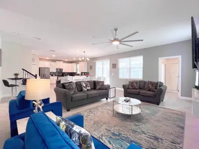 a living room with blue couches and a table at 8 Bed Storey Lake Resort- Huge Bedroom for Kids home in Kissimmee