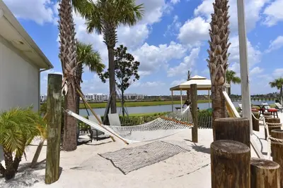 a hammock on the beach with palm trees at 8 Bed Storey Lake Resort- Huge Bedroom for Kids home in Kissimmee