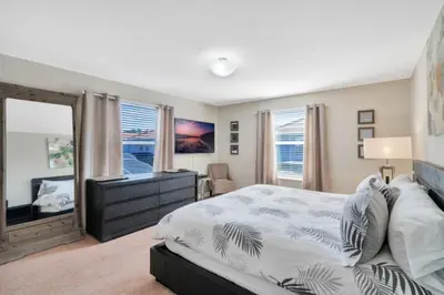 a bedroom with a bed and a desk and a window at Bismarck Palms home in Kissimmee