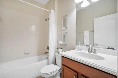 a bathroom with a sink and a toilet and a tub at Bismarck Palms home in Kissimmee