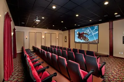 a cinema room with red chairs and a screen at Bismarck Palms home in Kissimmee