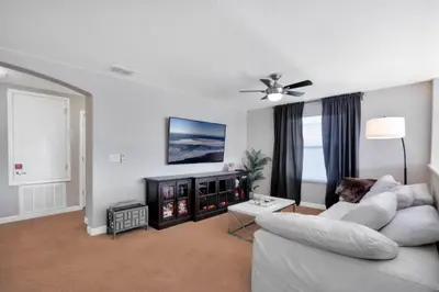 a living room with a white couch and a fireplace at Bismarck Palms home in Kissimmee