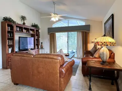 a living room with two leather couches and a tv at Cozy 4 Bed 3 Bath Private Pool Home with Game Room home in Kissimmee