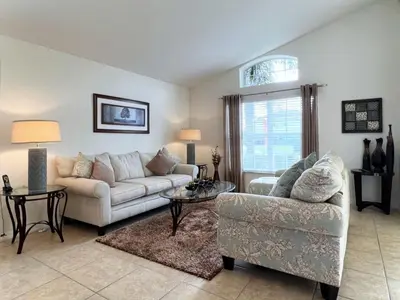 a living room with a couch and a chair at Cozy 4 Bed 3 Bath Private Pool Home with Game Room home in Kissimmee