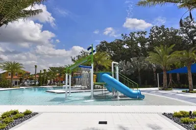 a swimming pool with a slide in a resort at Cozy 4 Bed 3 Bath Private Pool Home with Game Room home in Kissimmee