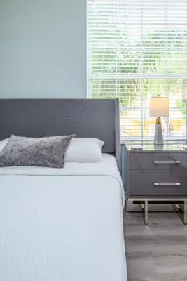 a bedroom with a bed and a nightstand and a window at Vista Cay Lakeview Elysium condo in Orlando