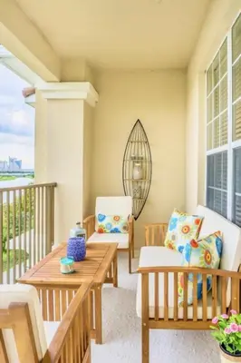a porch with two chairs and a wooden table at LakeView Penthouse Elegance condo in Orlando
