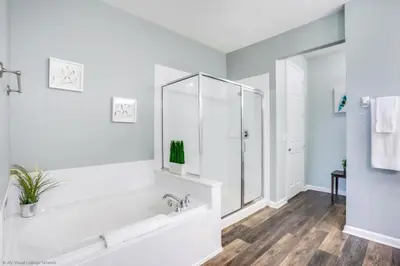a white bathroom with a tub and a shower at Lake View 3 Bedroom In Vista Cay Resort condo in Orlando