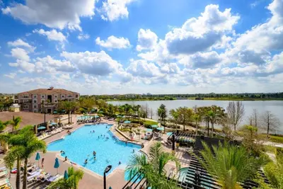 an image of a pool at a resort with a lake at Pool View Penthouse condo in Orlando