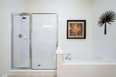 a bathroom with a shower and a bath tub at Pool View Penthouse condo in Orlando