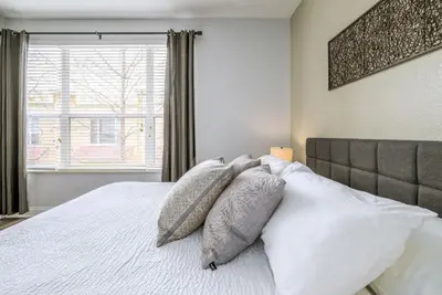 a bedroom with a white bed with pillows and a window at Vista Cay Casa Bella townhouse in Orlando