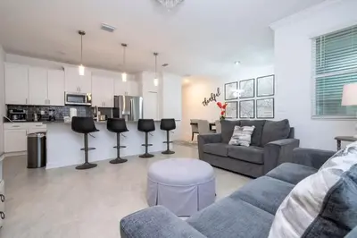 a living room with a couch and a kitchen at Gorgeous 4Bd with Pool at Storey Lake Resort 4475 in Kissimmee