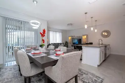 a kitchen and living room with a table and chairs at Gorgeous 4Bd with Pool at Storey Lake Resort 4475 in Kissimmee